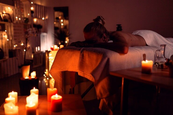 Femme allongée pour un massage dans une pièce tamisée
