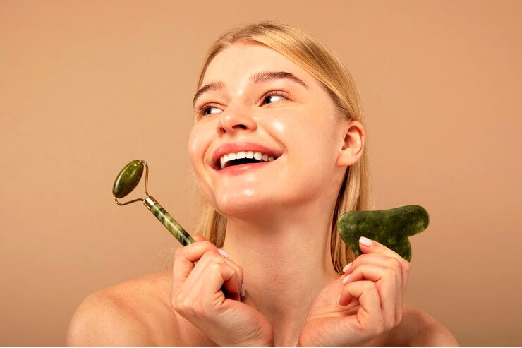 Femme souriante avec jade massage Gua Sha