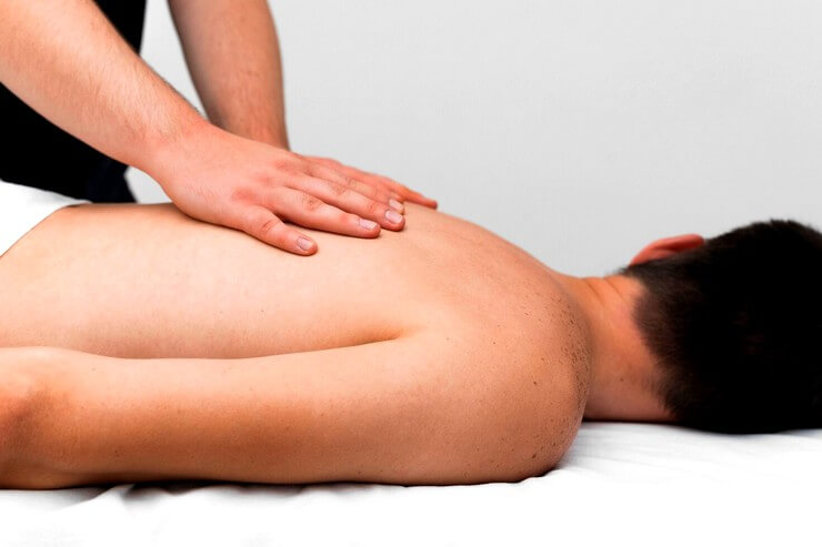 Massage sur le dos d'un homme avec la technique de l'effleurage