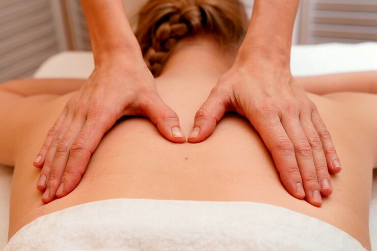 Massage sur le dos d'une femme avec la technique de l'effleurage