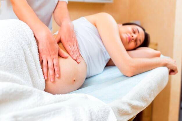 Massage sur le ventre d'une femme enceinte