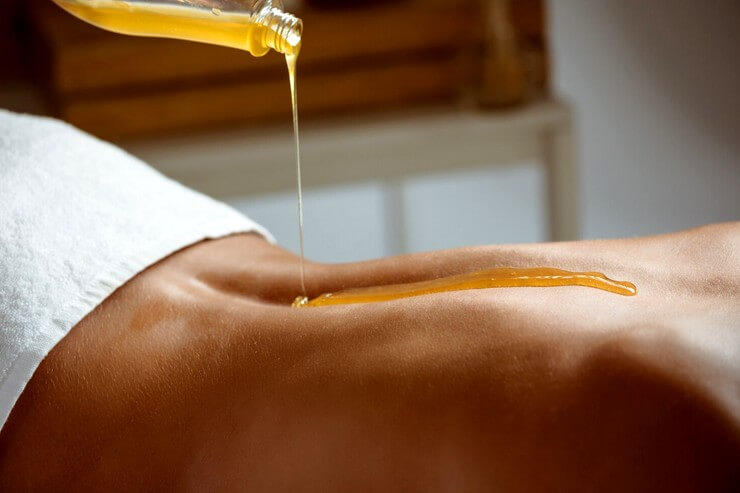 Mettre de l'huile sur le dos d'une femme pour un massage relaxant