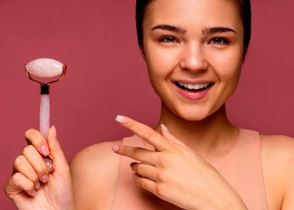 femme montre le rouleau de massage de jade pour son visage