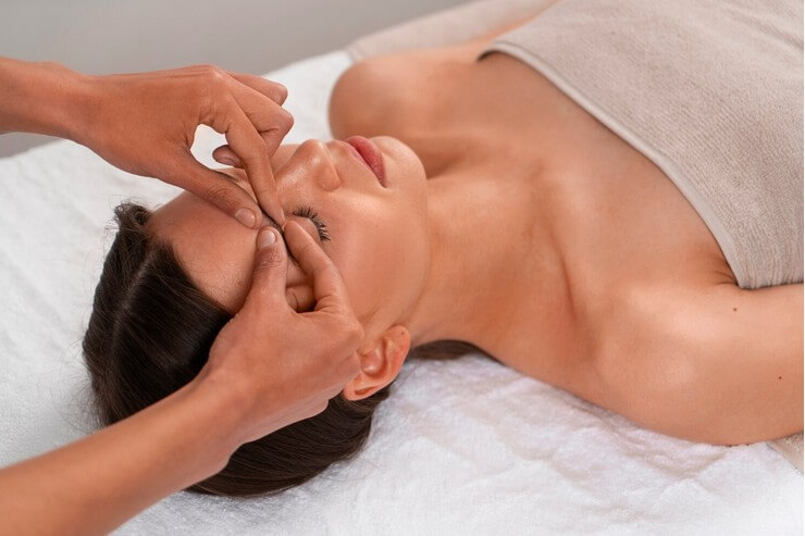 Massage kobido d'une femme sur le visage