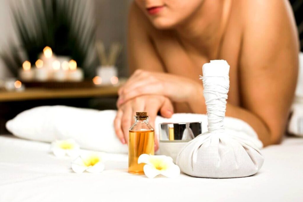 Femme à côté d'une huile de massage